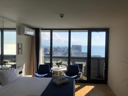 Un dormitorio con una cama y una mesa y sillas. en Fort sea view, en Batumi