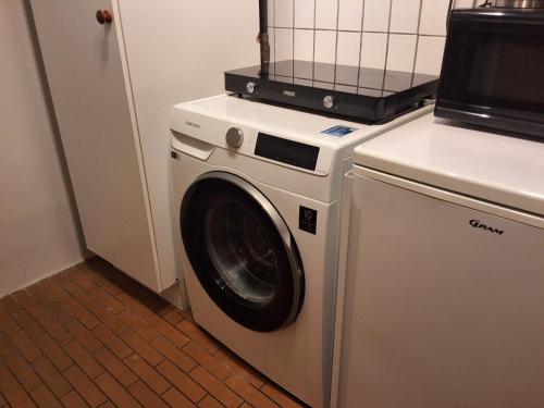 a washer and dryer sitting in a kitchen at Lille bolig med egen indgang in Holte