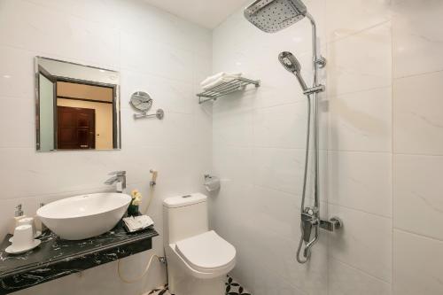 a bathroom with a sink and a toilet and a shower at Cat & laundry hotel in Hanoi