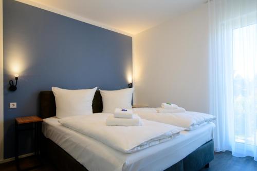 ein Schlafzimmer mit einem Bett mit zwei Handtüchern darauf in der Unterkunft Smart & Stay Aparthotel Saarbrücken Süd - Self-Check-In - Free Parking in Saarbrücken