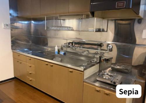 a stainless steel kitchen with a stove and a sink at Room 2type Fuji Trip House Sepia 3F and Deneb 4F in Azagawa