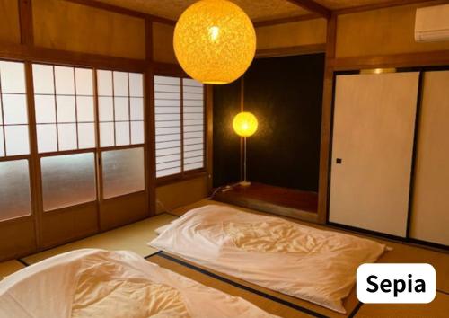 a bedroom with a bed in a room with windows at Room 2type Fuji Trip House Sepia 3F and Deneb 4F in Azagawa