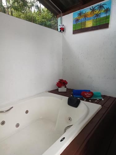 a white bath tub sitting in a room at Chalé com jacuzzi Florianópolis in Florianópolis