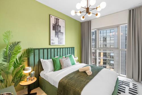 a bedroom with a bed with green walls and a window at Luxury Radiant Boulevard Residence in Mushayrib