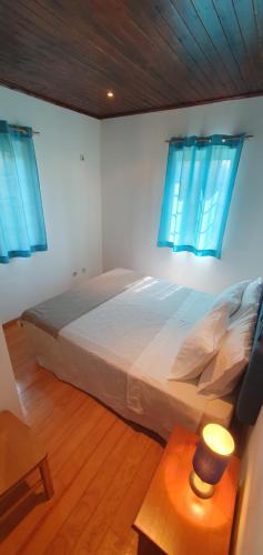 a bedroom with a large bed with blue windows at Quinta do Santo no Douro - Casa T3 in Alcarias