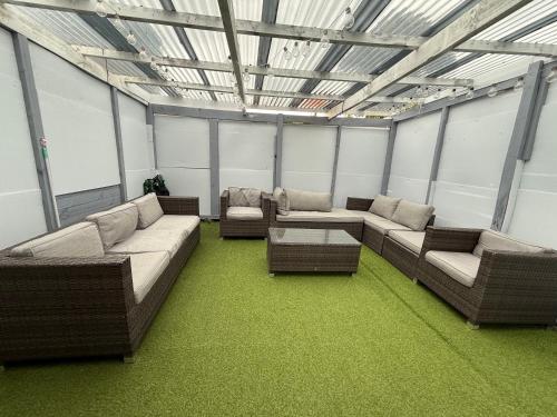 a large room with couches and tables and windows at 2-bed granny flat near Auckland Airport in Auckland