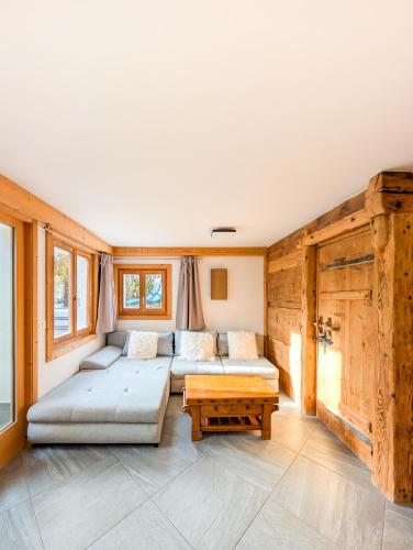 a living room with two couches and a table at Appt de charme dans chalet - cosy & nature in Villars-sur-Ollon