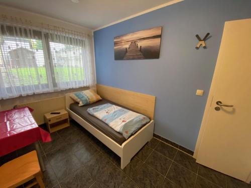 a small room with a bed and a window at Mayer-Pension in Ludwigshafen am Rhein