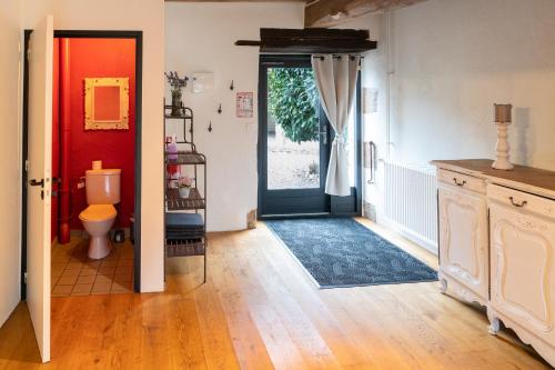 a hallway with a bathroom with a toilet and a door at Maison 2 in Souvigny