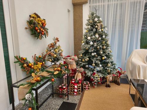 eine Gruppe von Weihnachtsbäumen in einem Wohnzimmer in der Unterkunft 25,000sq.ft Grand Luxe Villa PJ 13BR 42Pax By Verano in Petaling Jaya