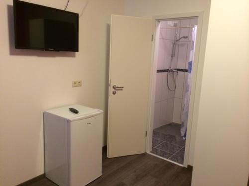 a bathroom with a shower and a television on the wall at Mayer-Pension in Ludwigshafen am Rhein