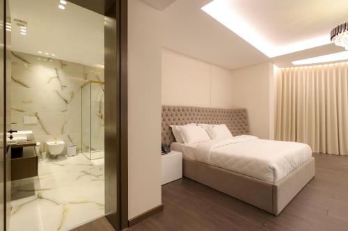 Un dormitorio con una cama tamaño king y un baño. en Si'Hana Hotel, en Elbasan