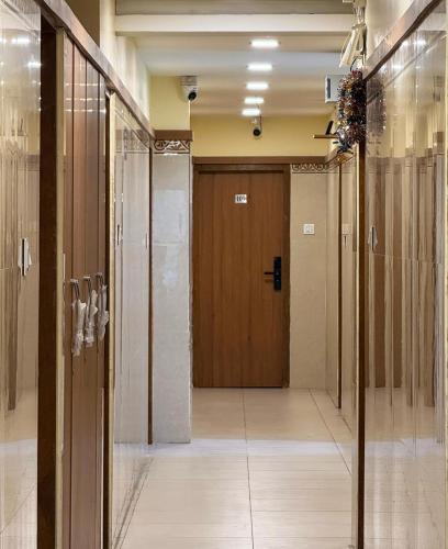 a hallway with a wooden door in a building at Lakshmi Narayana Grand in Kanchipuram