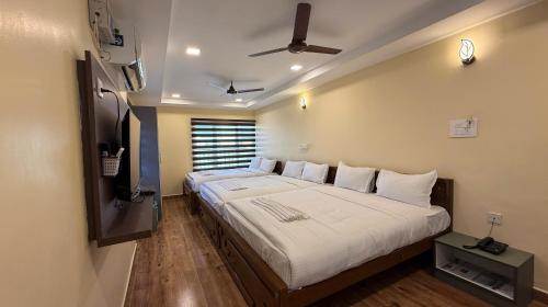 ein Schlafzimmer mit einem großen Bett und einem Fernseher in der Unterkunft Lakshmi Narayana Grand in Kanchipuram