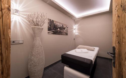 a small room with a bed and a large vase at Aurina Lodges in Lutago