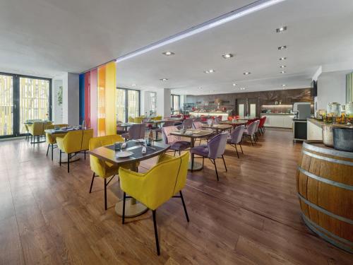 Un restaurante con mesas y sillas y un bar. en Clarion Congress Hotel Bratislava, en Bratislava