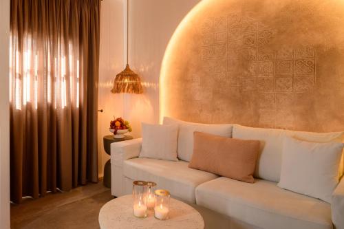 a living room with a white couch and a table at Themis Coddess Cave Suites in Santorini