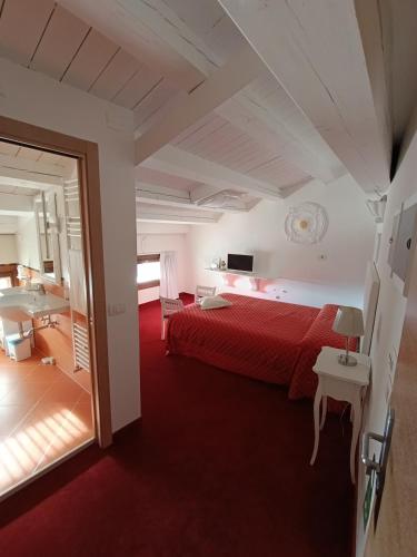 a hotel room with a red bed and a mirror at Villa Marini Trevisan in Aviano