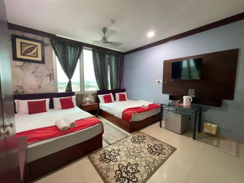 a hotel room with two beds and a television at Saujana City Hotel - Nearby KLIA in Bandar Saujana Putra