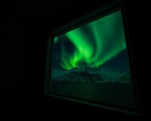 ein Bild der Nordlichter auf einem Fernsehbildschirm in der Unterkunft Polar Panorama Lodge in Fjordgård