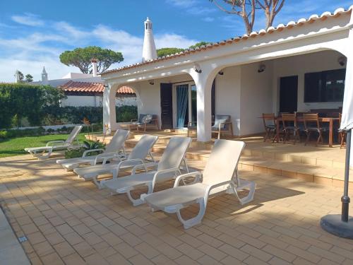 una fila di sedie bianche sedute su un patio di Alsouk a Vilamoura