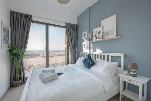 a bedroom with a white bed and a large window at Free housekeeping visits during your stay - StayShort - Extravagant 1BR near Town Square - Sleeps 4 in Nadd Shubayḩ