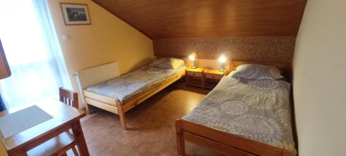 a small room with two beds and a table at Pokoje Gościnne VEIKSME in Bestwina