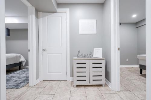 ein Schlafzimmer mit einer weißen Tür und einer weißen Kommode in der Unterkunft Renovated 2 Bedroom Basement Apartment Near 401 and Amenities in Bowmanville