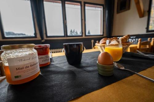 a table with jars of food and an egg and a glass of orange juice at Auberge Restaurant du Virage in Chamrousse