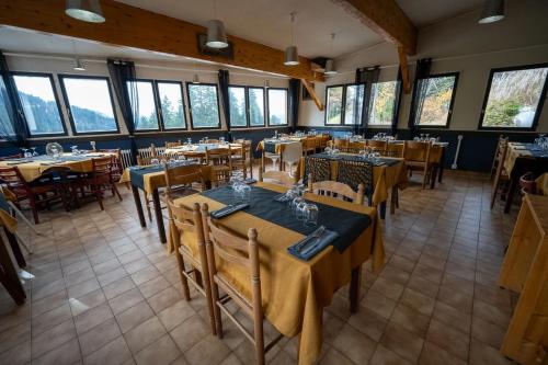 a restaurant with tables and chairs in a room with windows at Auberge Restaurant du Virage in Chamrousse