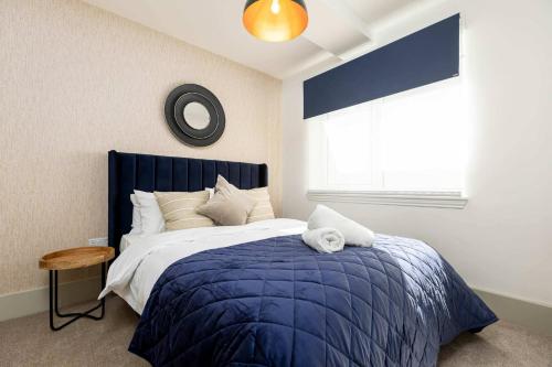 a bedroom with a blue bed and a window at Apartment Seven Pelican House in Bournemouth