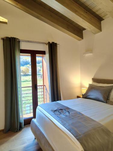 a bedroom with a bed and a large window at Maria Luisa Mountain Lodge in Rovere