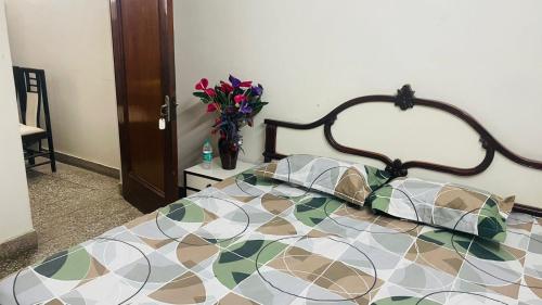 a bedroom with a bed and a vase of flowers at Gavari India's Delhi Hostel in New Delhi