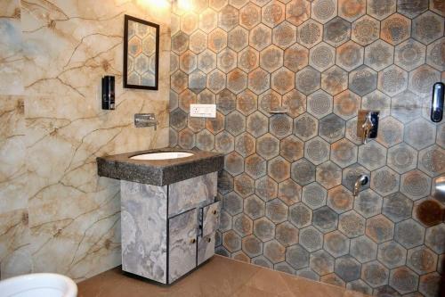 bagno con lavandino in pietra e parete piastrellata di Sarins Mistville 4BHK Villa Mall Road a Mussoorie