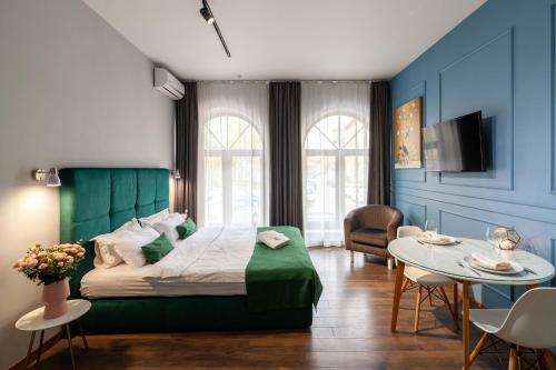 a bedroom with a bed and a table and chairs at AUSTRIAN APART HOTEL in Lviv