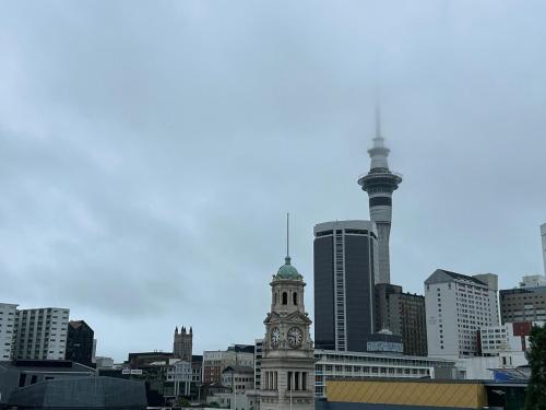 a view of a city with a clock tower at Auckland CBD Apartment with Sky Tower View in Auckland