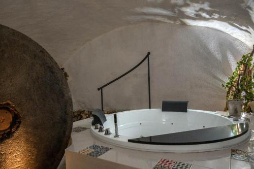 Zimmer mit Badewanne in der Mitte eines Zimmers in der Unterkunft Grotta azzurra - Suite e spa in Monticello