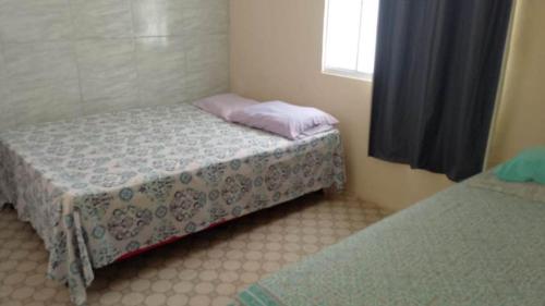 Un dormitorio pequeño con dos camas y una ventana. en capongabeachce, en Cascavel