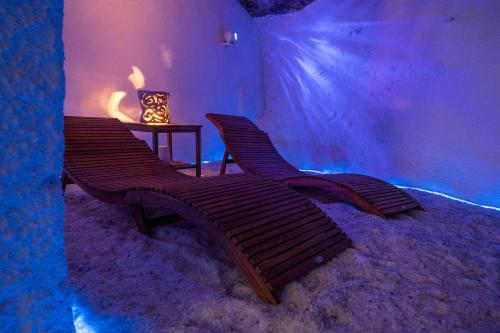 zwei Holzbänke in einem Zimmer mit einem Tisch in der Unterkunft Grotta azzurra - Suite e spa in Monticello