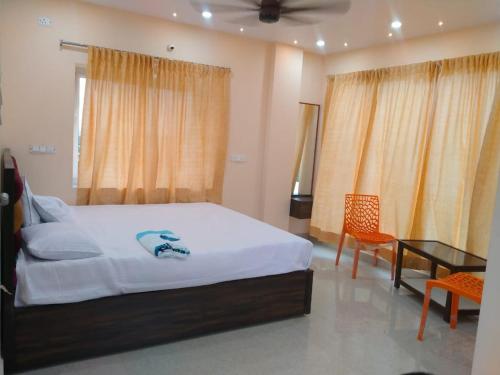Un dormitorio con una cama y una mesa y sillas. en MK sea view guest house, en Visakhapatnam