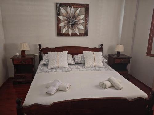 a bed with two pillows on it with two tables at apartman house Bjedov in Povlja