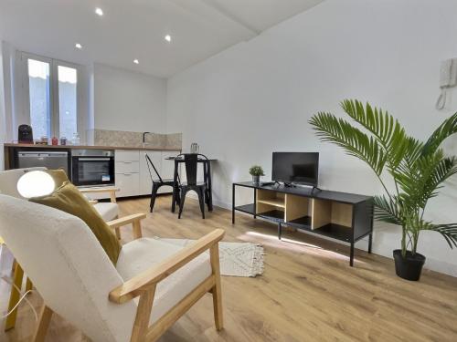 un salon avec une chaise et une table avec une plante dans l'établissement Le Cornas, à Tournon-sur-Rhône