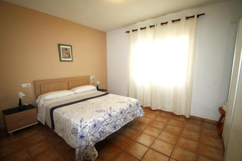 a bedroom with a bed and a large window at Villa Atenea in Miami Platja