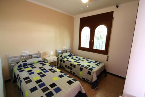 a bedroom with two beds and two windows at Villa rustical 14 in Montroig