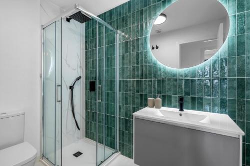 a green tiled bathroom with a sink and a shower at Casa La Vida Bella in San Miguel de Salinas