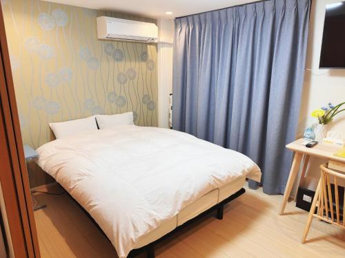 a small bedroom with a white bed and a desk at 阿久津ハイツ102 in Tokyo