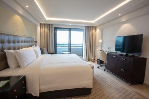 Una habitación de hotel con una cama grande y un televisor. en Abuja Continental Hotel, en Abuja