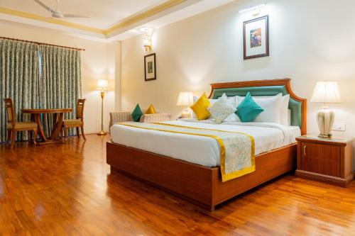 卡齐兰加ROYALE de' CASA RESORT KAZIRANGA的一间卧室，里面有一张大床和一张桌子。