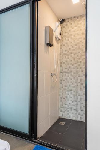 a bathroom with a shower with a glass door at Lachata - Hua Mak in Bangkok