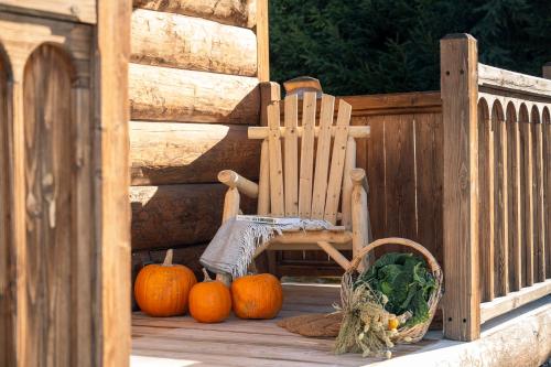 a wooden porch with pumpkins and a wooden chair at Leśna Chatka in Dzianisz